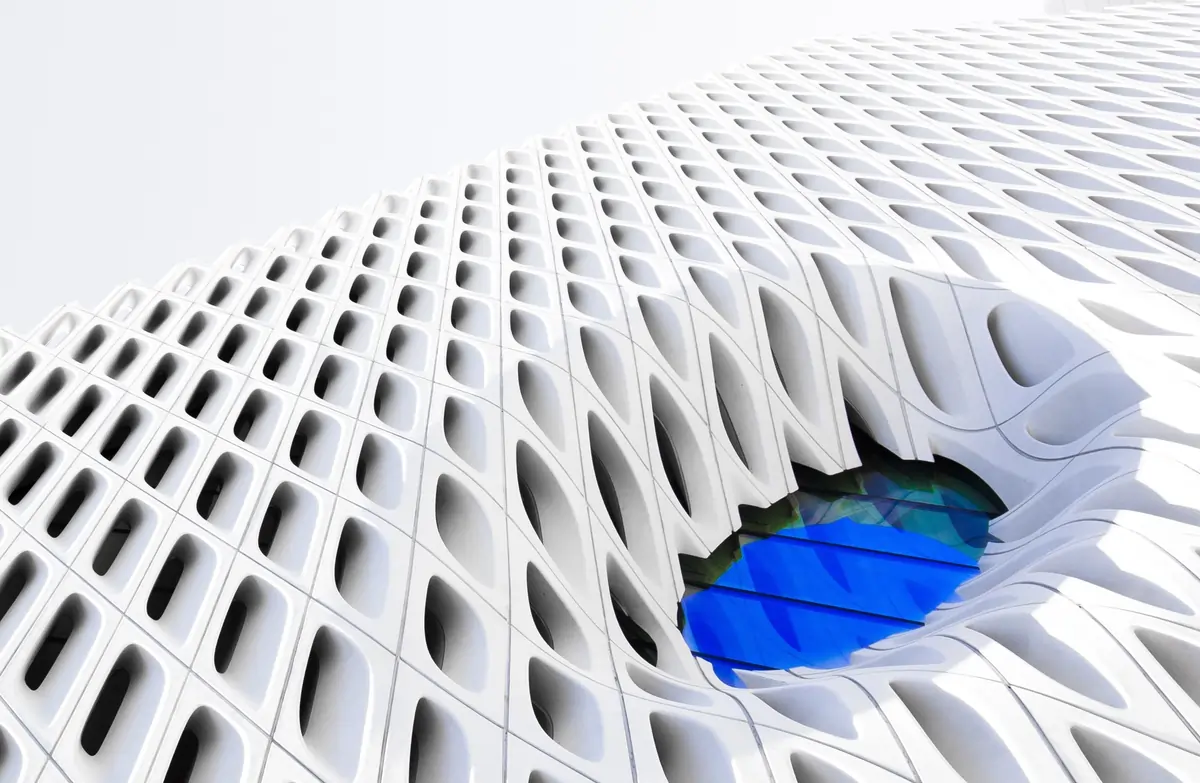 an architectural sculpture with a blue window looking into the future like an eye